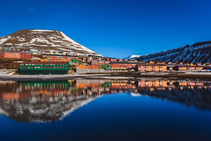 Krajina Severního ledového oceánu a reflexe s modrou oblohou a zimními horami se sněhem, Norsko, Špicberky, Longyearbyen