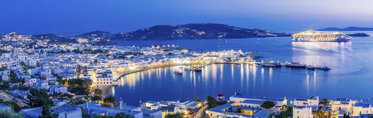 Krásný večerní pohled na Mykonos s odplouvající výletní lodí, Řecko